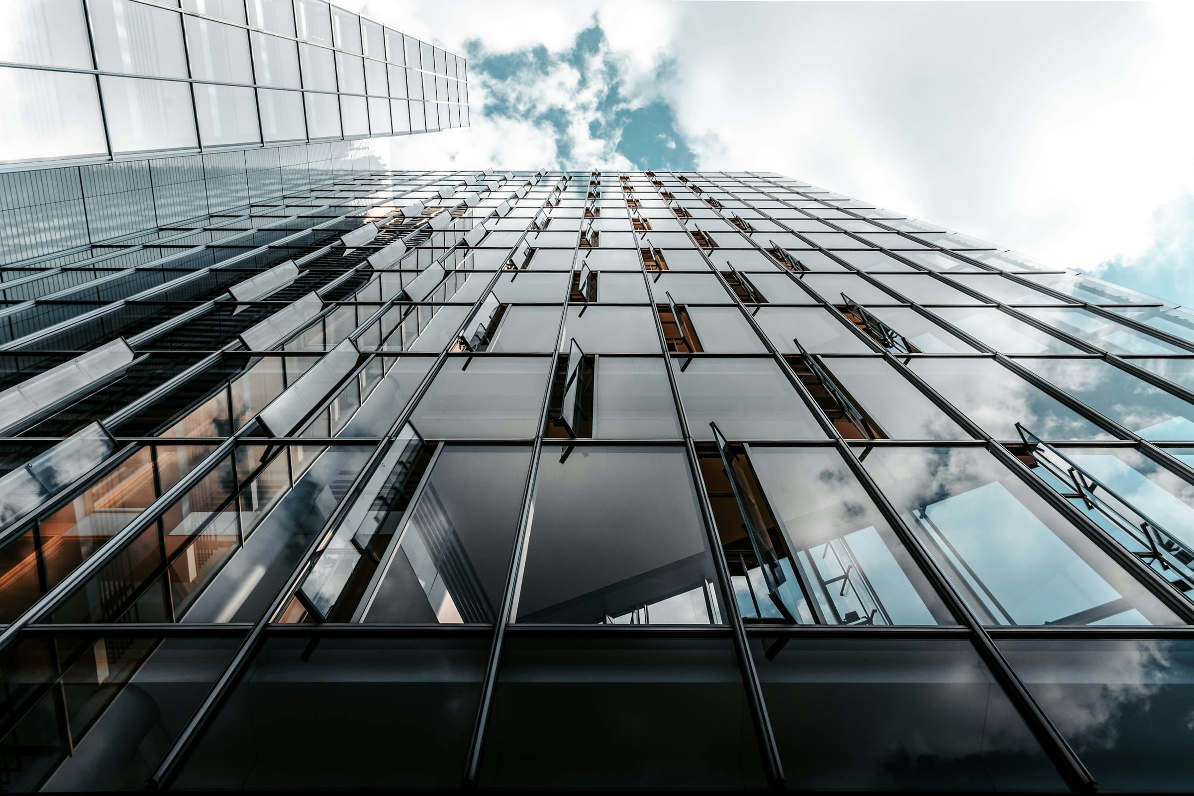 Modern glass office tower reflecting the sky