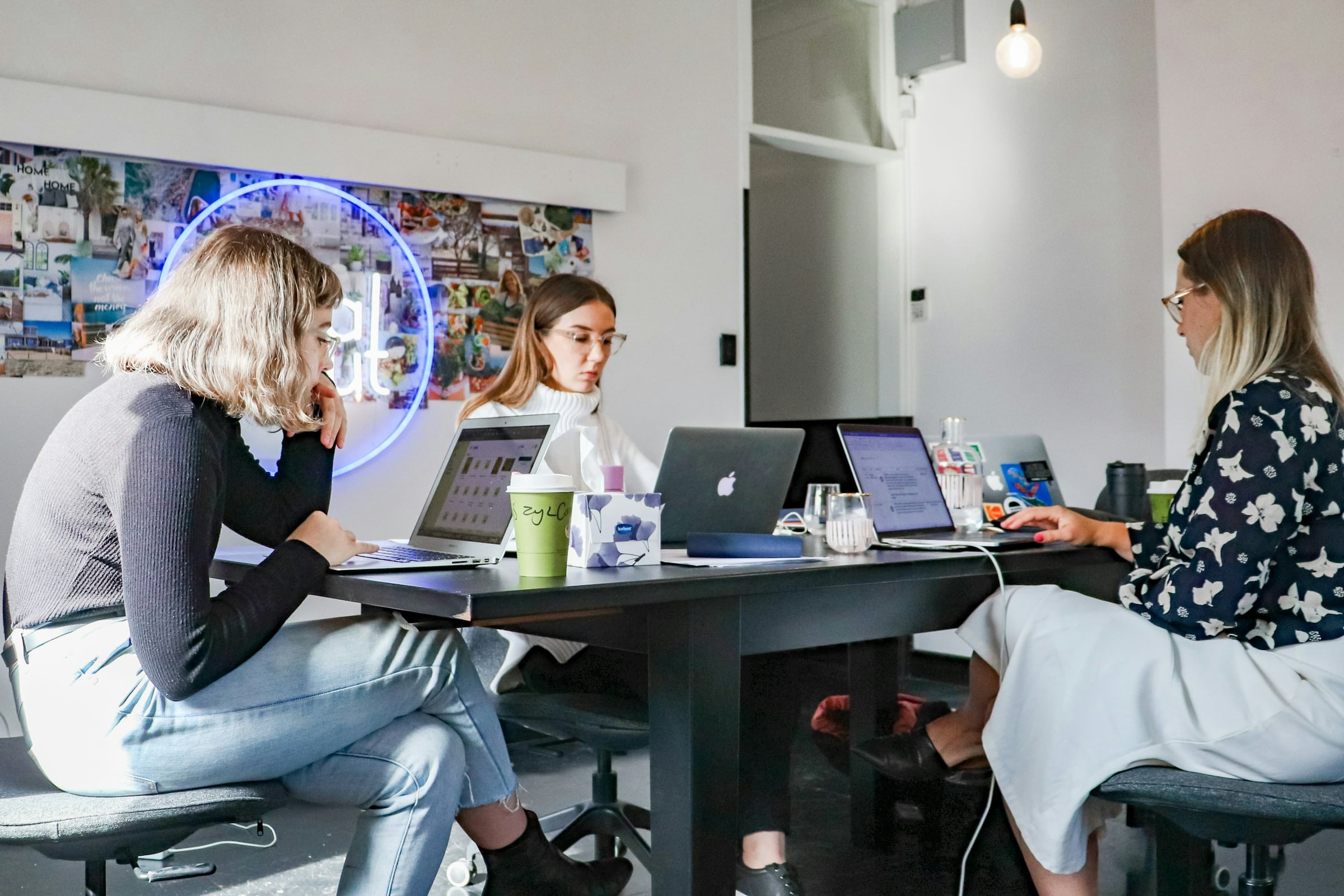 Marketing team working together on laptops around a table