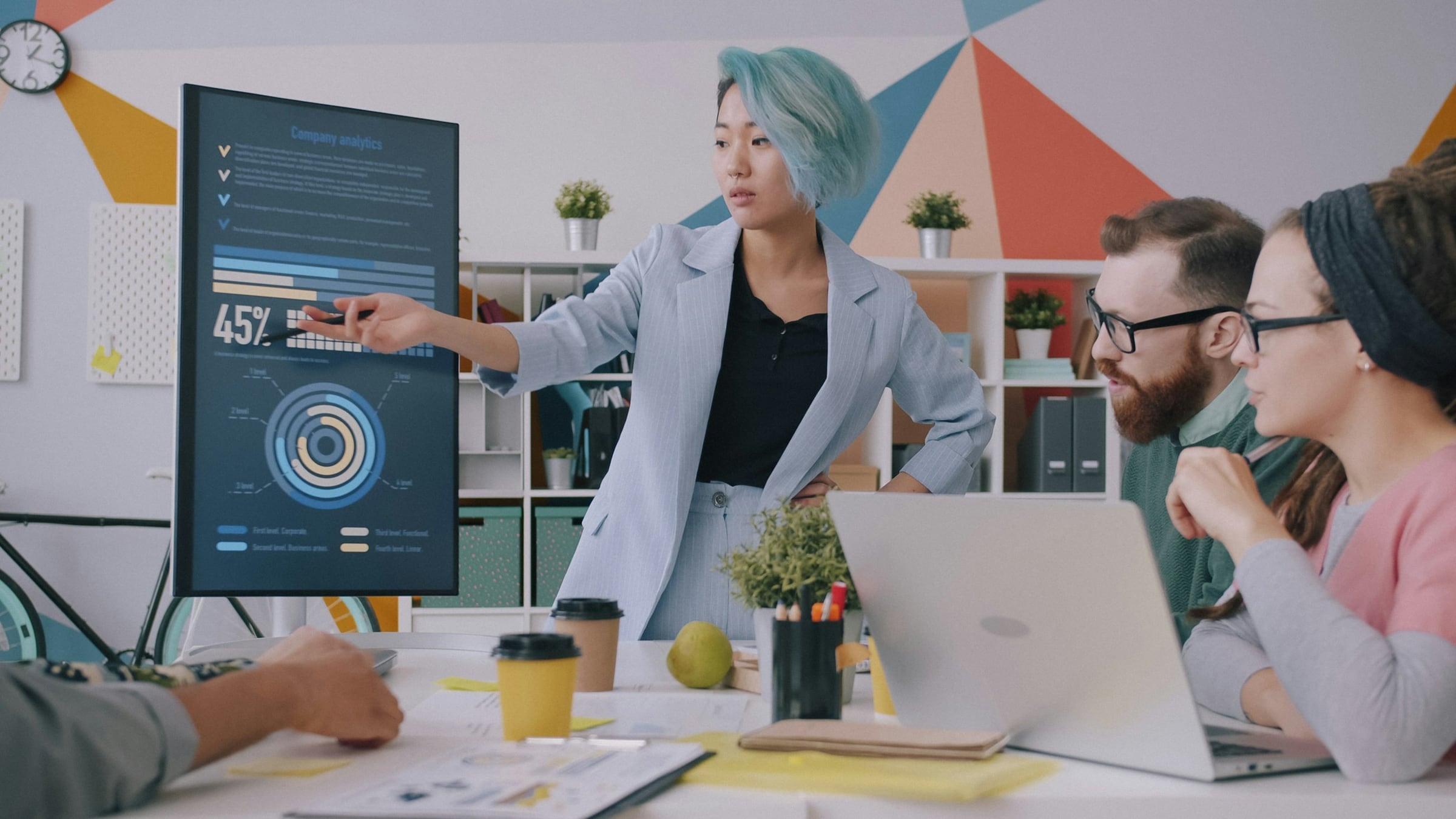 Team member presenting shared data on a screen in an office meeting