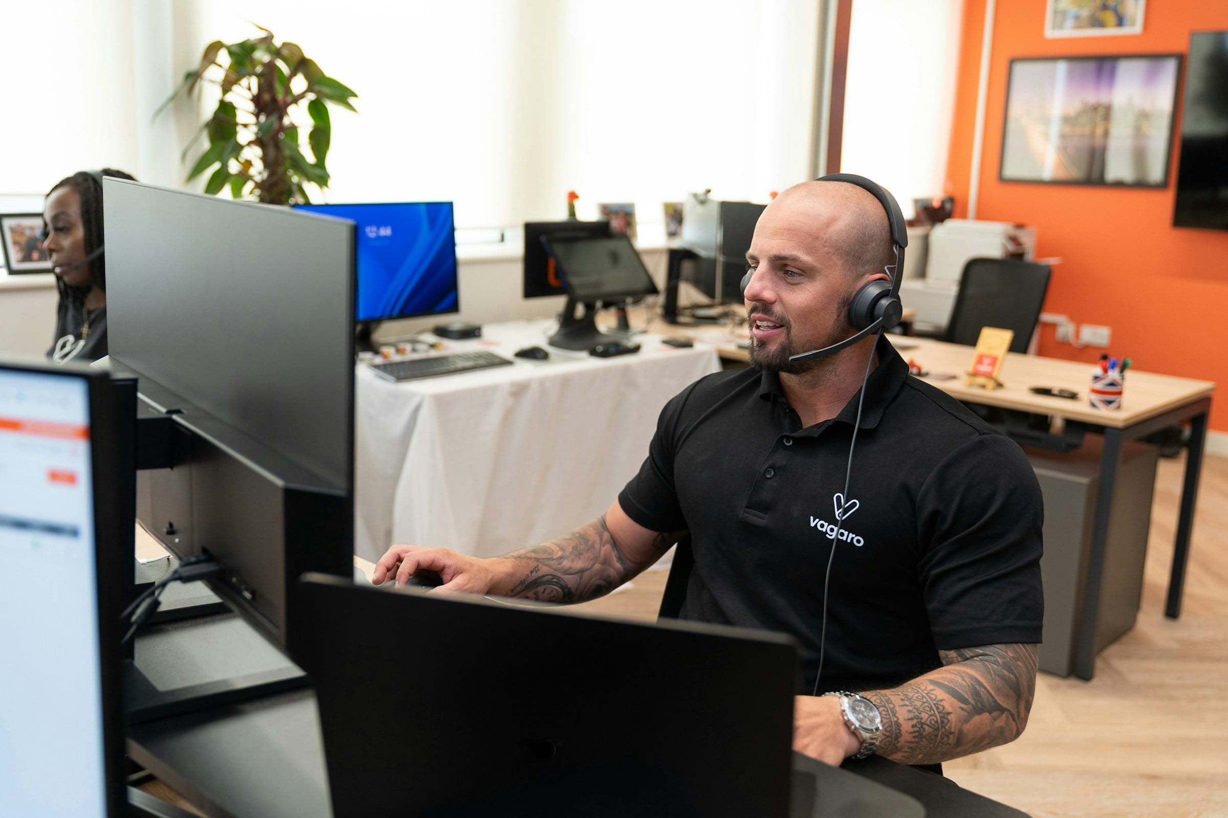 Customer support specialist wearing a headset at his workstation