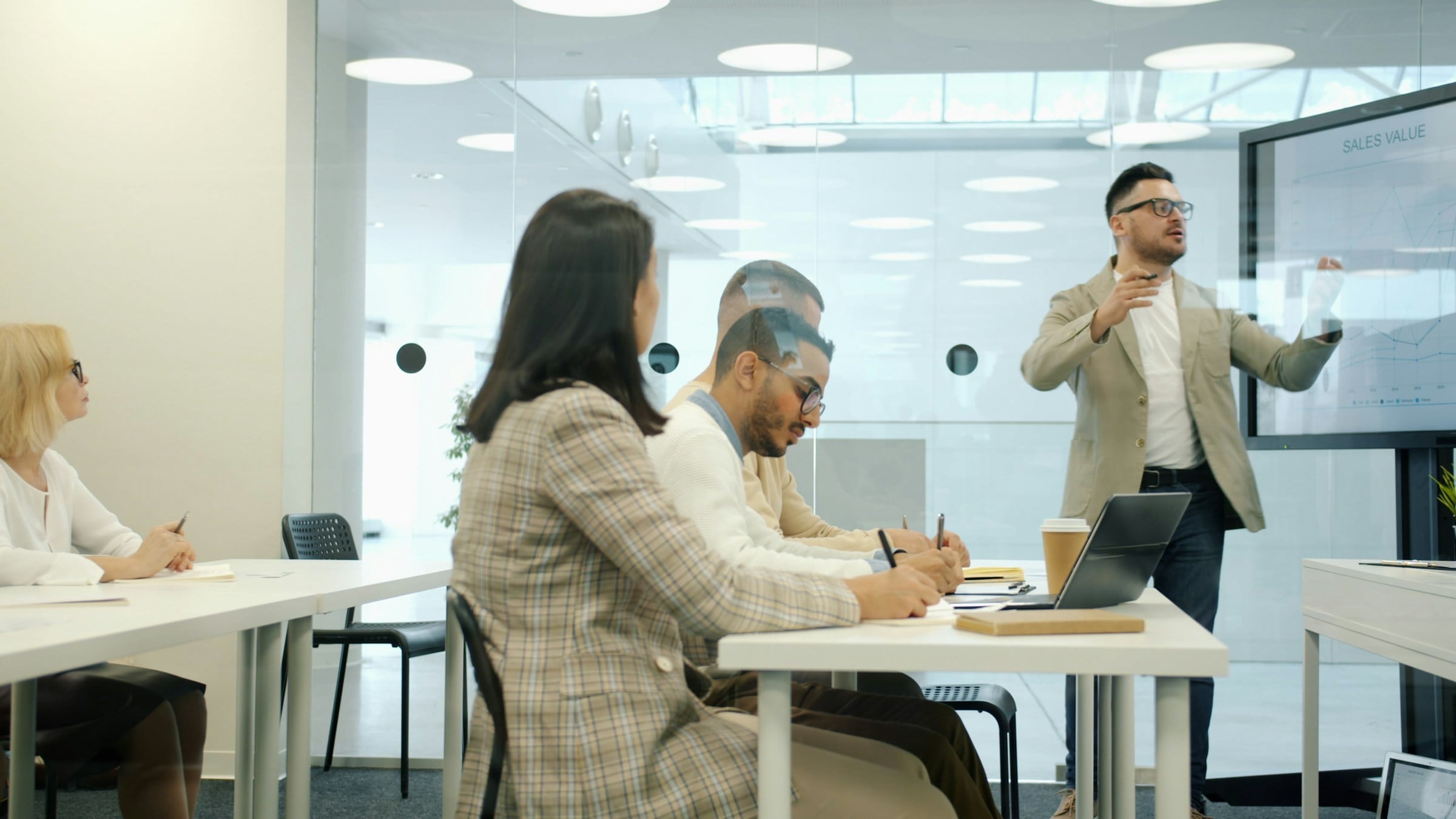 Trainer presenting to colleagues in a modern meeting room